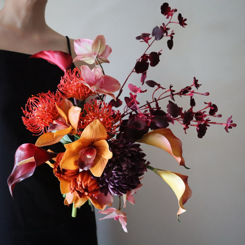 ワインカラーとテラコッタカラーの動きのあるクラッチブーケ