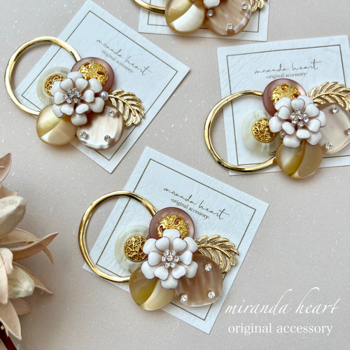 ゴールドとパステルオレンジのポニーフック ホワイトフラワーとライト  