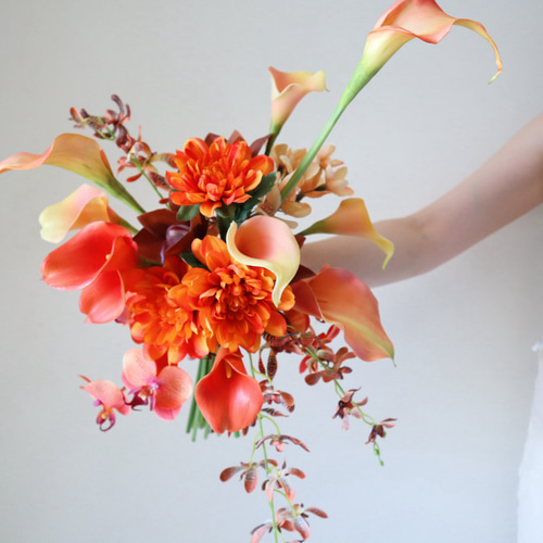 花嫁様の肌を美しく魅せる人気花材のオレンジクラッチブーケ
