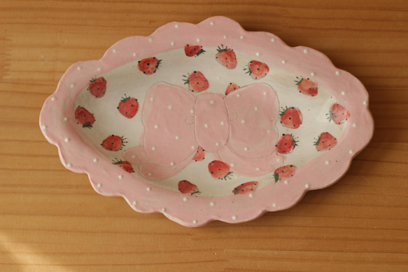 粉狀粉紅色圓點褶邊絲帶和草莓盤。 第1張的照片