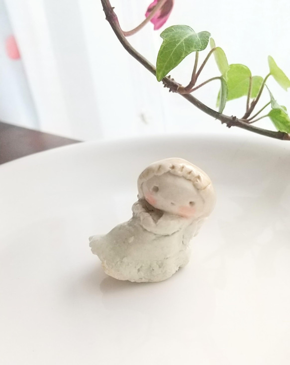 座る小さな天使の陶人形 1枚目の画像