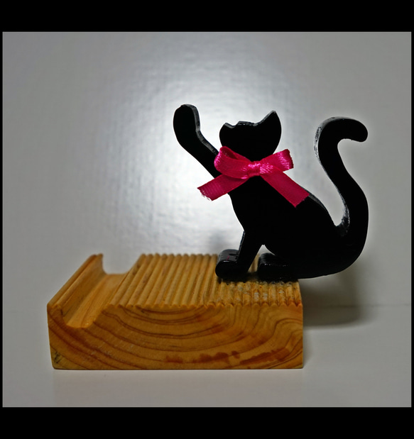 【手作りのスマホ置き ちょこ】黒猫ちゃんが片手でひょいとスマホを支えてるデザイン 2枚目の画像