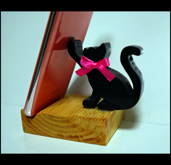 【手作りのスマホ置き ちょこ】黒猫ちゃんが片手でひょいとスマホを支えてるデザイン 1枚目の画像