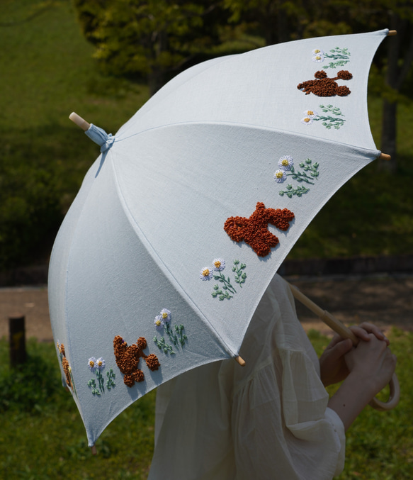 プードル刺繍の日傘（水色リネン生地に茶系プードル8頭）UV加工済み 1枚目の画像