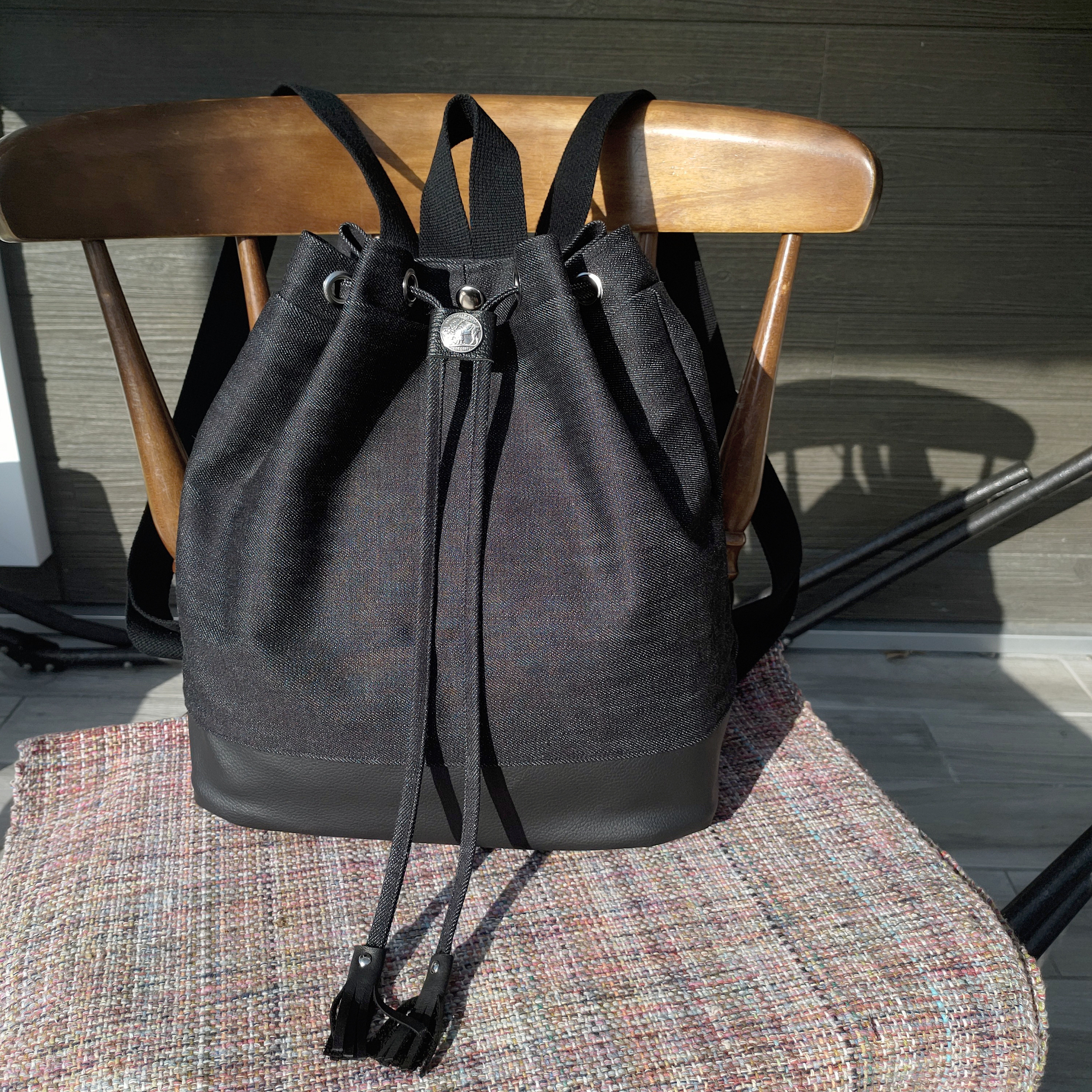 ブラックデニム×レザーの異素材コンビ　巾着型リュック　コインコンチョつき　大きめサイズ　ブラック