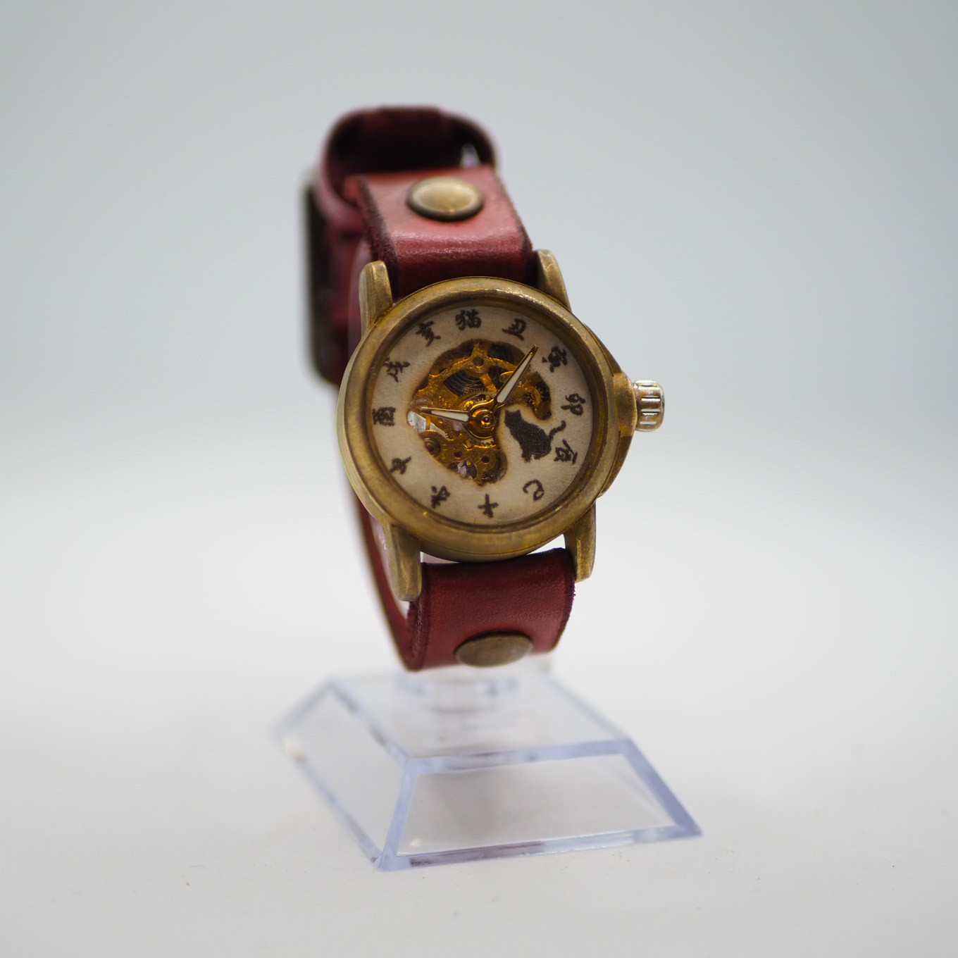 黒猫が手巻き式腕時計を眺める腕時計　座り子黒猫