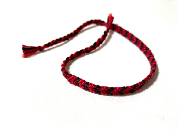 刺繍糸で編んだV字模様のミサンガ (レッド×ブラック) 1枚目の画像