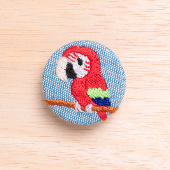 ベニコンゴウインコの刺繍くるみブローチ(青) 1枚目の画像