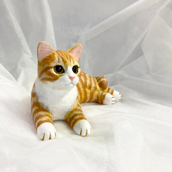 棕色虎斑白貓雕像 第1張的照片