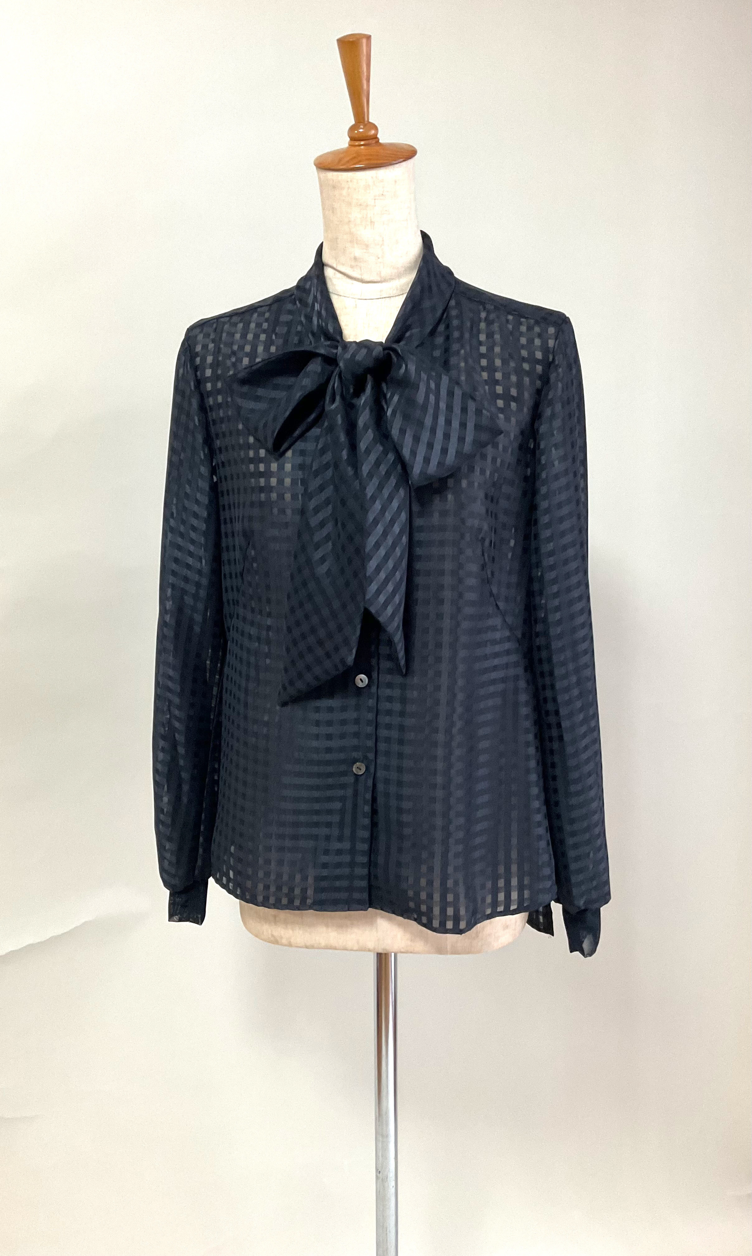 「現在早納」大きなリボンのブラウス、透け感のある格子柄、黒。袖口 メッシュカフス。