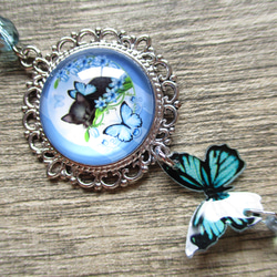 ◇3410再販 ✨青い花蝶と黒猫の妖精　本革紐のネックレス ※約50㎝ 1枚目の画像