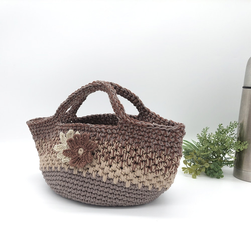 編み手はカバンを持って弁当パックを持っています Crochet flower pattern lunch bag made with cotton yarn