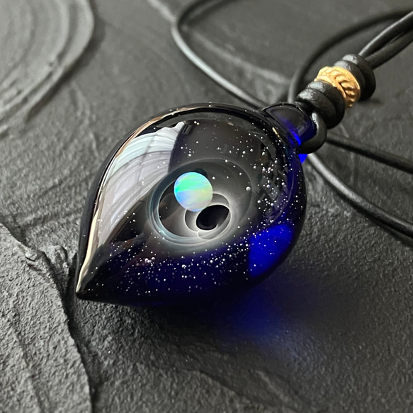 海、波、宇宙っぽさを感じられるデザインのガラスのネックレス