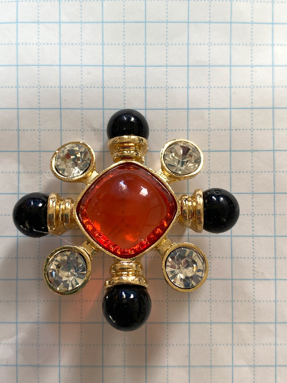 118〜結晶の形をして、オレンジ色のひし形の周りにクリスタルダイヤと，墨色の珠をつけたブローチA 8枚目の画像