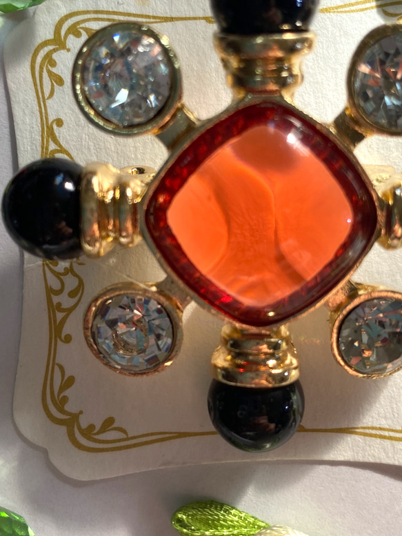 118〜結晶の形をして、オレンジ色のひし形の周りにクリスタルダイヤと，墨色の珠をつけたブローチA 4枚目の画像