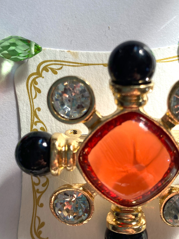 118〜結晶の形をして、オレンジ色のひし形の周りにクリスタルダイヤと，墨色の珠をつけたブローチA 5枚目の画像