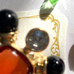 118〜結晶の形をして、オレンジ色のひし形の周りにクリスタルダイヤと，墨色の珠をつけたブローチA 3枚目の画像