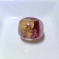 乳白色に赤紫の帯と金箔をのせてピンクの桜を咲かせたとんぼ玉 1枚目の画像