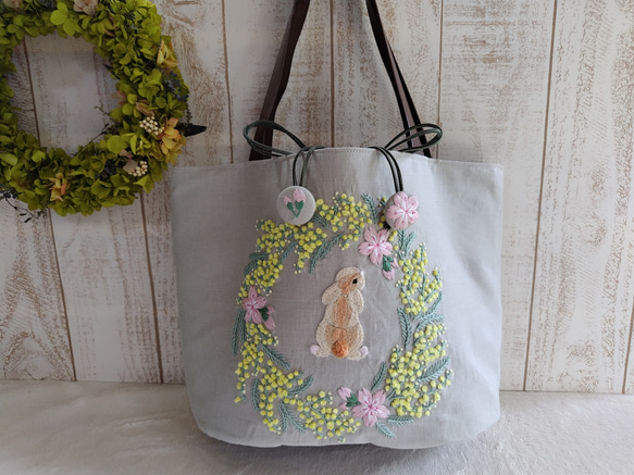 *手刺繍*桜＆うさぎ＆ミモザのリース*リネン×リバティ「yoshie」カーキ系*楕円底の巾着形トートバッグ* 1枚目の画像