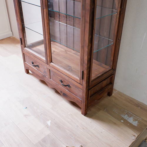 ダークブラウンのガラスキャビネット ロートアイアン取っ手仕様