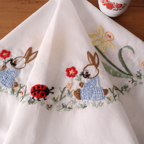 ドイツの手仕事/水色のお洋服のうさぎやてんとう虫・スイセンの手刺繍 コットン生地テーブルクロス (ヴィンテージ ウサギ） 1枚目の画像