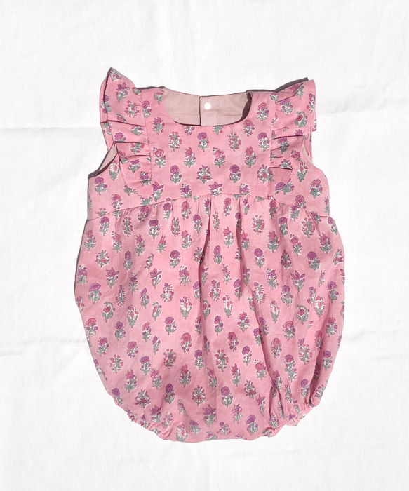 ピンク地に小花柄の ブロックプリントのフリルロンパース サイズ80