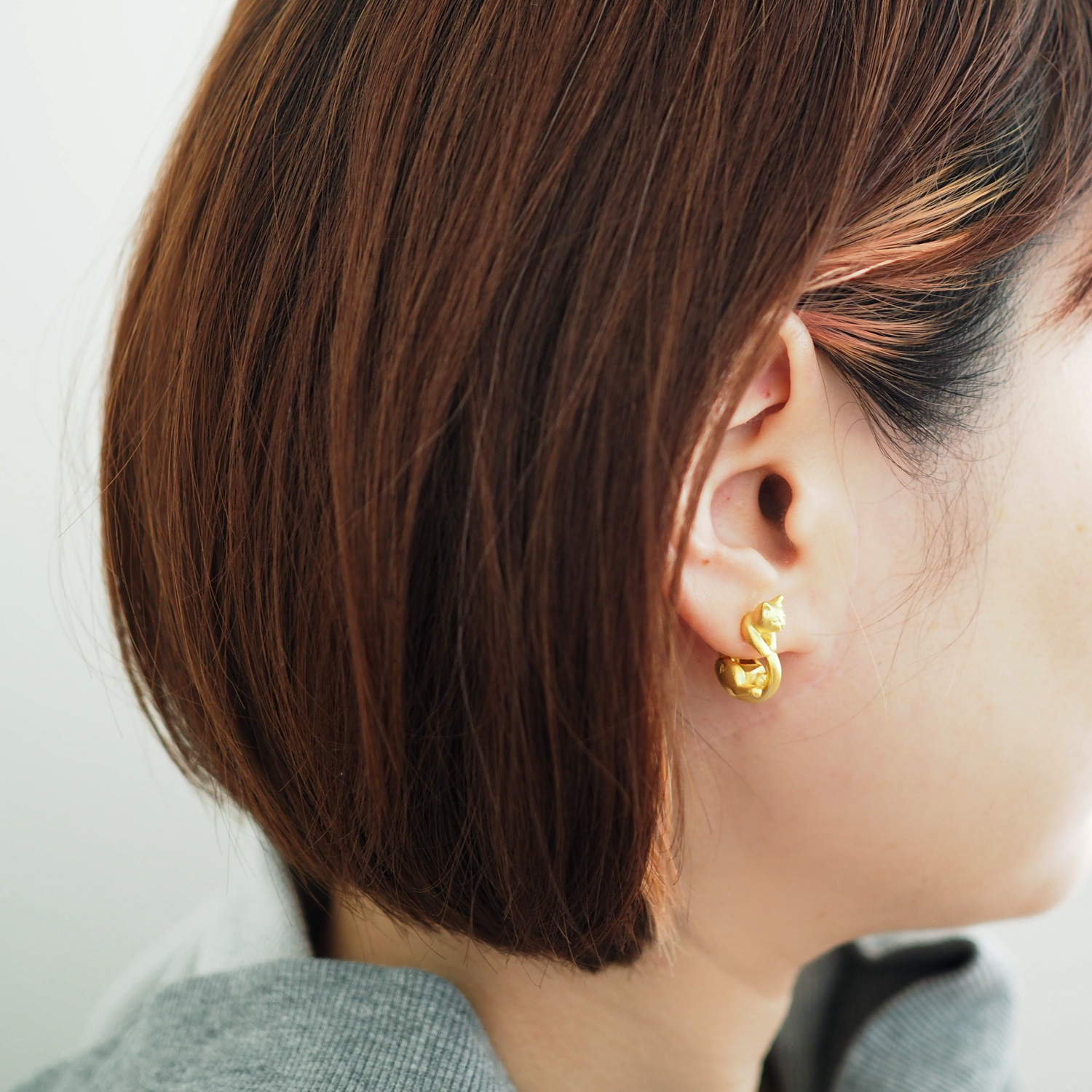 くるんと丸まった猫イヤリング マットゴールド ラテュ・片耳