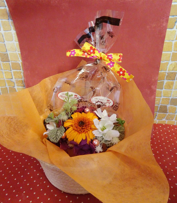 花柄の陶器にアレンジしたオレンジのガーベラのプリザーブドフラワーと海の生き物などの形の焼き菓子２袋のギフトセット 1枚目の画像