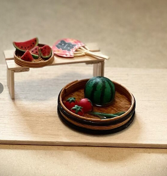 ミニチュア夏の風物詩:冷えたスイカ、夏野菜、うちわ、カットスイカの 