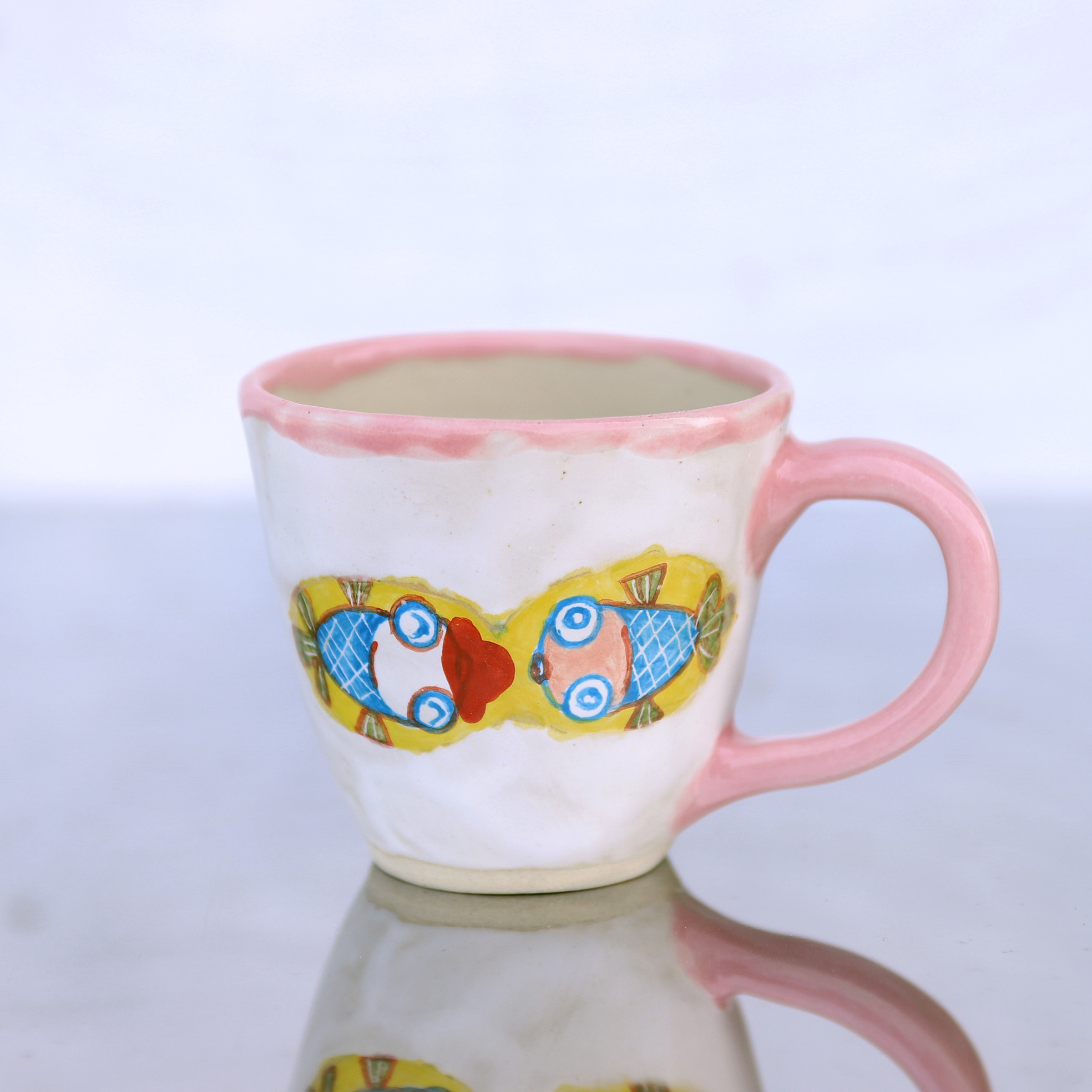 白釉と赤い帽子をかぶった金魚絵のマグカップ（ピンクの取っ手）