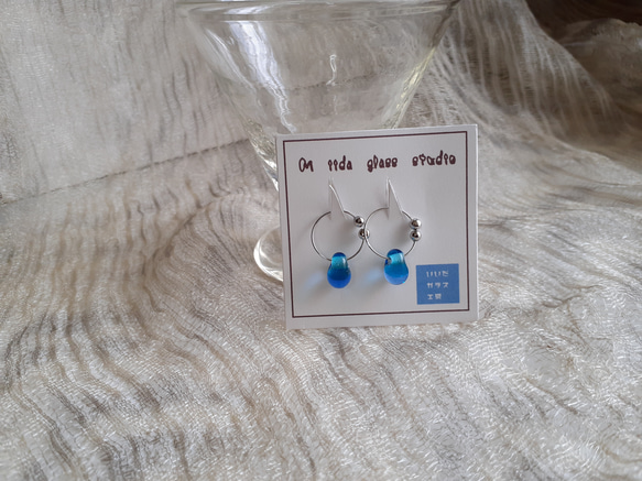 雫型エメラルドグリーンとブルーのツートンカラーのガラスのピアスに見えるイヤリング 1枚目の画像