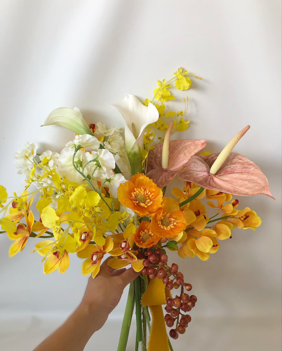 オレンジウェディングブーケ　シンビジューム　アンスリウム　カラー ■ハンドメイドですので デリケートな商品もございます お取扱いには十分お気を付けください ■ご使用の日 着日指定などあり 急ぎの配達をご希望の方は前もって納期の確認をお願いいたします また 造花を使用している為前撮り→挙式→披露宴と長くご使用頂けます ご使用後も インテリアとしてお楽しみ頂け結婚式の思い出を色褪せる事なく残す事が出来ます 丁寧にお作りしています お使いのパソコンによって画面上で見る色味と実際とで異なる場合が御座います