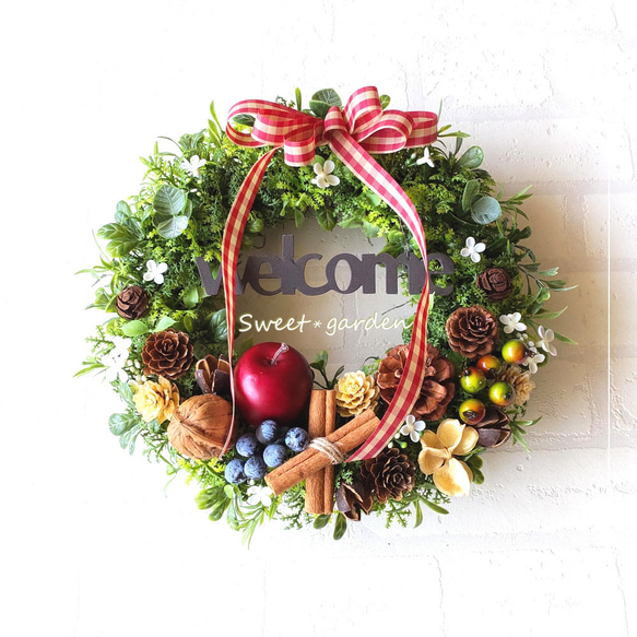 赤いギンガムチェックリボンを付けた真っ赤なアップルと木の実の  