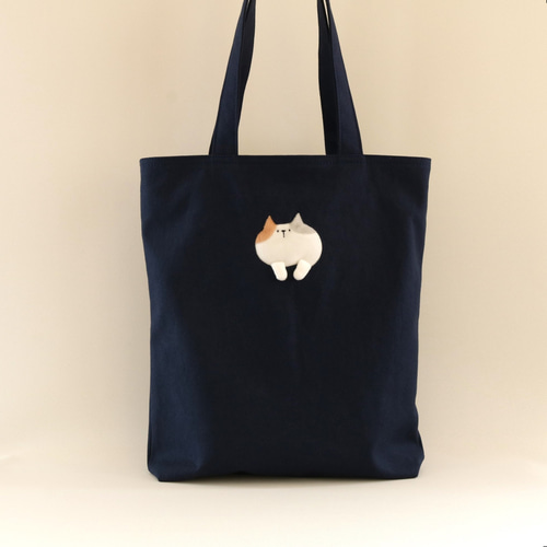 猫がぶら下がっているトートバッグ（パステル三毛猫 ネイビー A4