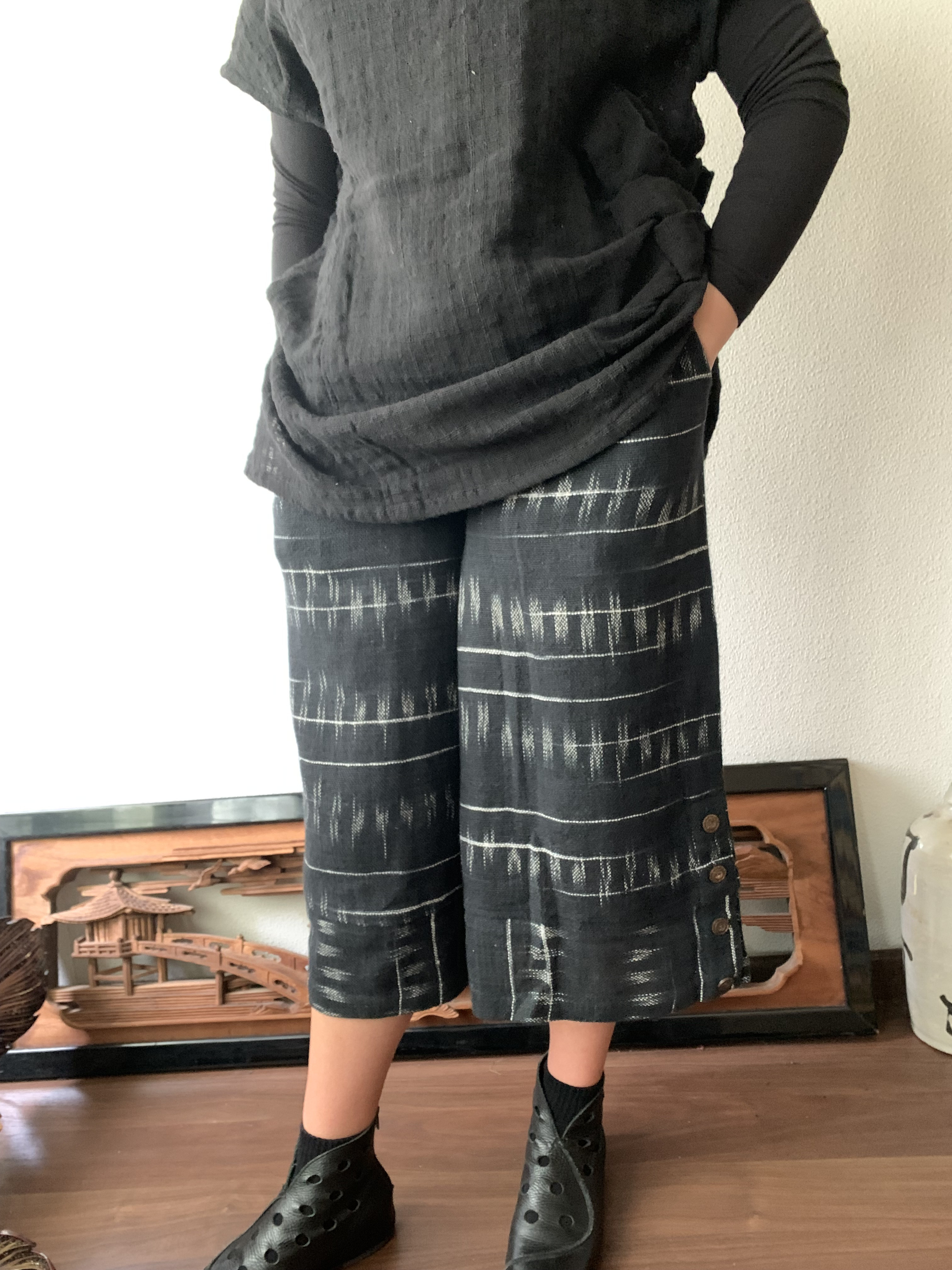 生地厚め手織り綿裾ワイドのガウチョ　すとんと落ちるシンプルラインで体型もすっきり、でも裾横ボタンで遊んでます　黒絣