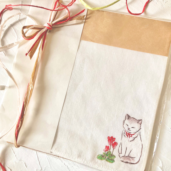 【再販】『シクラメンと赤いリボンの猫』の手描きリネンハンカチオフホワイト 1枚目の画像