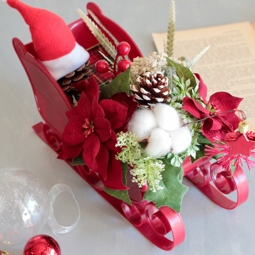 ソリに乗ったサンタクロースのポインセチアクリスマスアレンジ アート