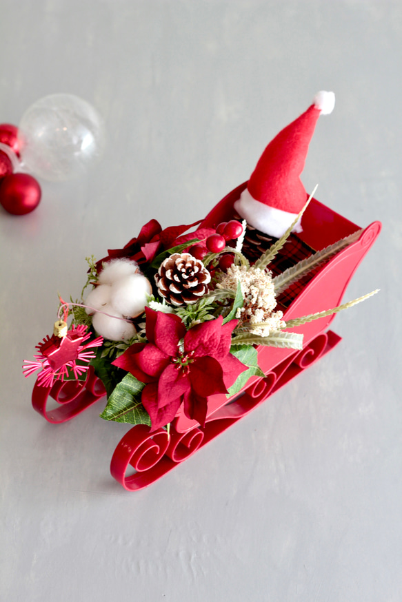ソリに乗ったサンタクロースのポインセチアクリスマスアレンジ 3枚目の画像
