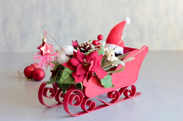 ソリに乗ったサンタクロースのポインセチアクリスマスアレンジ 2枚目の画像