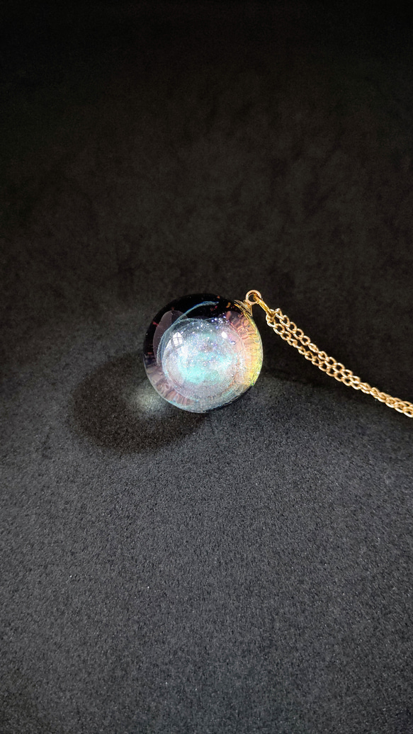 エメラルドグリーンの渦が輝く宇宙玉レジンの球体ネックレス 1枚目の画像