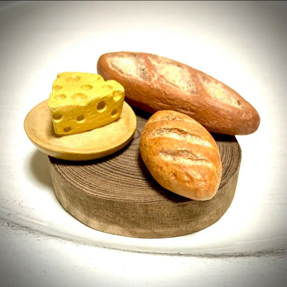 木で作ったパンと皿の上のチーズ(エンジュの木の切り株付き) 1枚目の画像