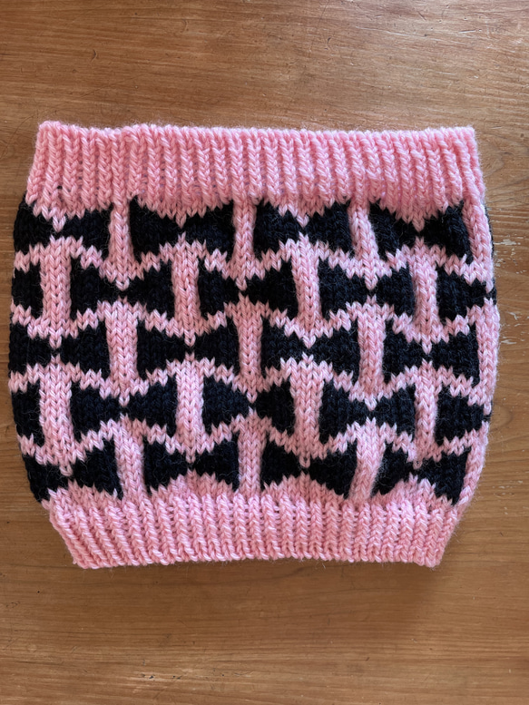 手編み　メリノウール100%のネックウォーマー　リボン柄　ピンクと黒 1枚目の画像