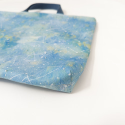 一款採用熊守原創面料製成的、以星夜為主題的淺色課包。 第2張的照片