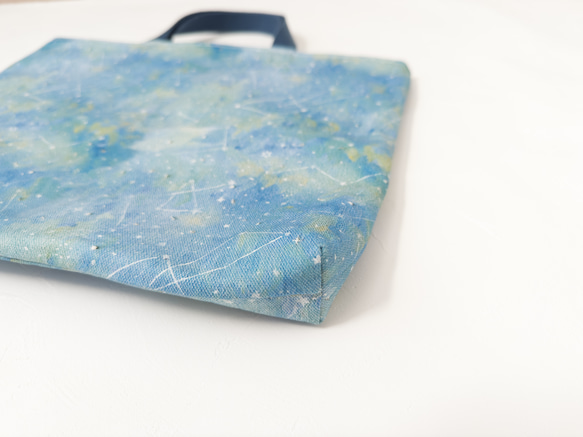 一款採用熊守原創面料製成的、以星夜為主題的淺色課包。 第2張的照片