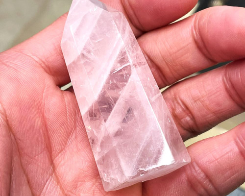 ローズクォーツのポイント原石 内部のクラックからレインボーが光る