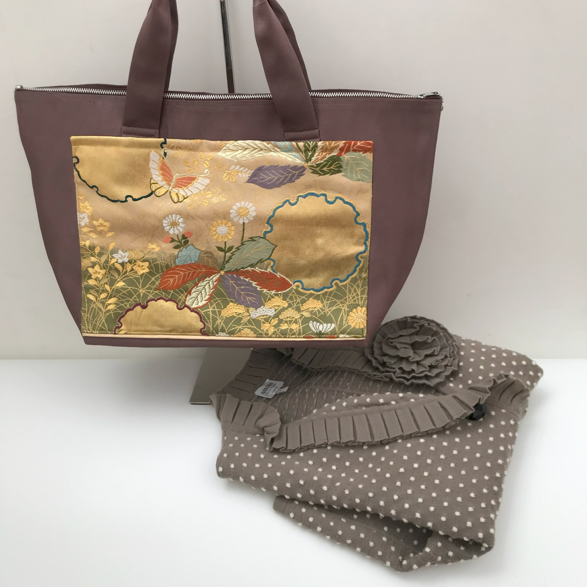 チョコレート色にゴールドの大きなポケットのファスナートート