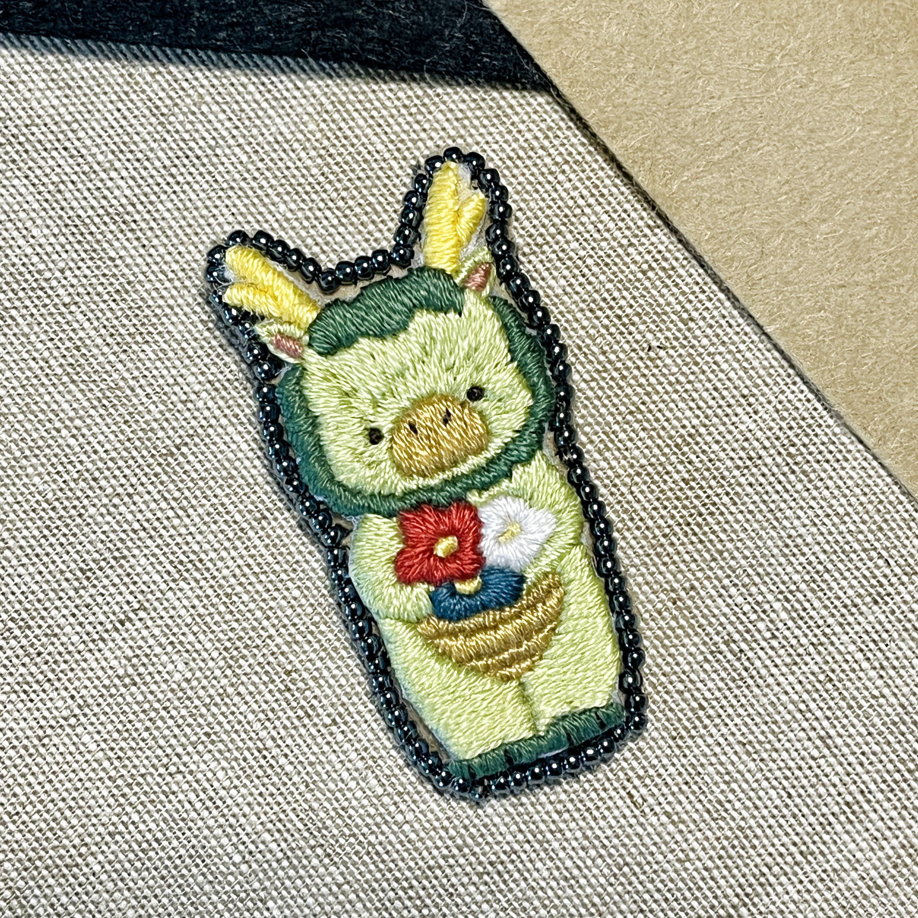 お花を抱える辰 手刺繍ブローチ【受注制作】