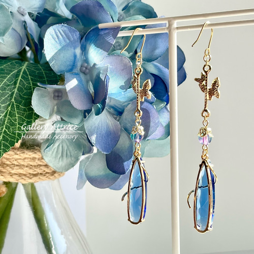 くるくると蝶が舞う ブルーのガラスチャームが美しいピアス