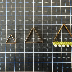 パールビーズを編み込んだ刺繡糸と金属フレームのピアス　～山吹色・トライアングル～ 2枚目の画像