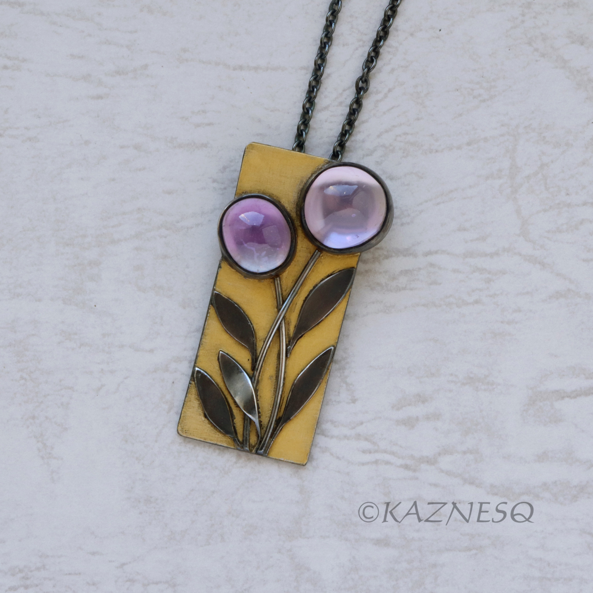 アメジストを白蝶貝で裏打ちしたもので作ったシルバーの花のペンダント